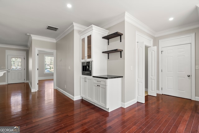 interior space with dark hardwood / wood-style flooring, white cabinetry, and crown molding