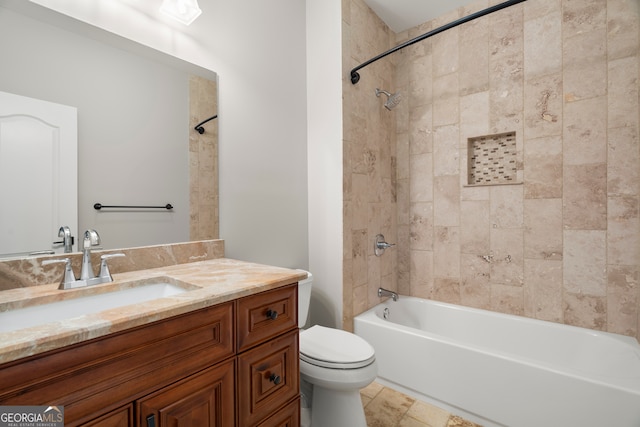 full bathroom featuring tiled shower / bath, vanity, and toilet