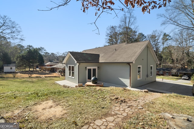 rear view of property with a lawn and a patio area