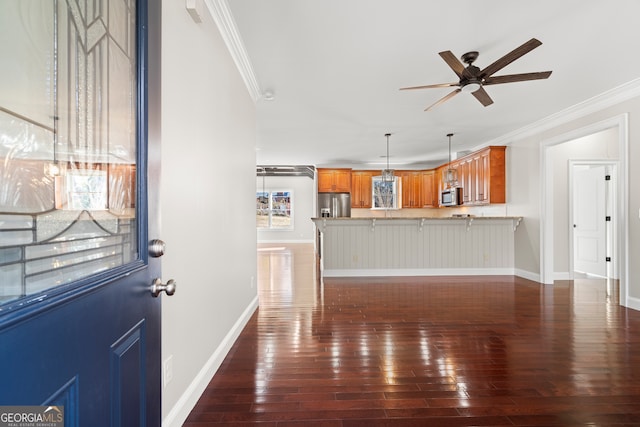 unfurnished living room with ceiling fan, dark hardwood / wood-style flooring, and ornamental molding