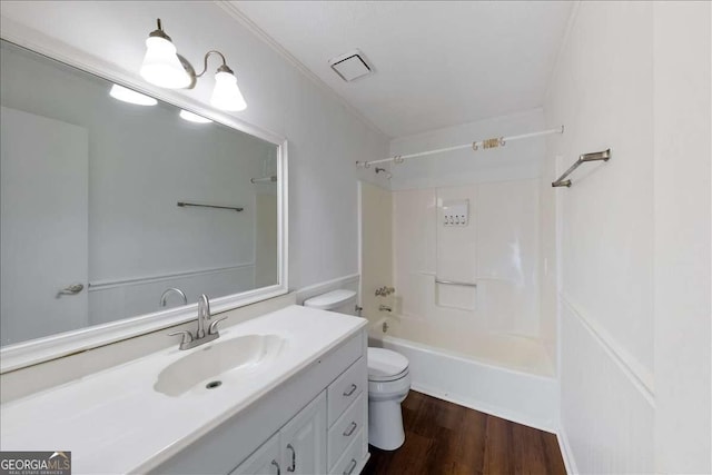 full bathroom with hardwood / wood-style flooring, shower / bathing tub combination, vanity, ornamental molding, and toilet