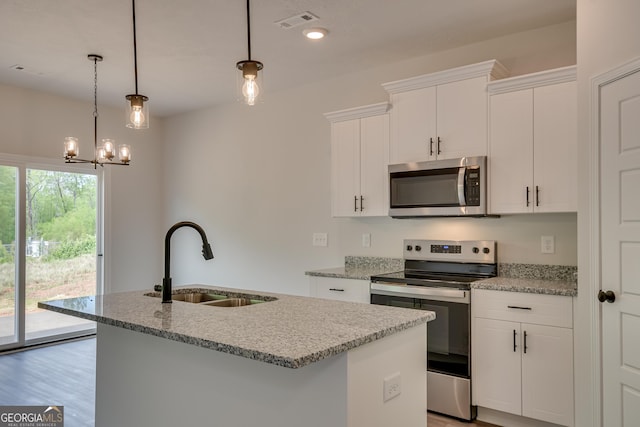 kitchen featuring stainless steel appliances, sink, decorative light fixtures, white cabinets, and an island with sink