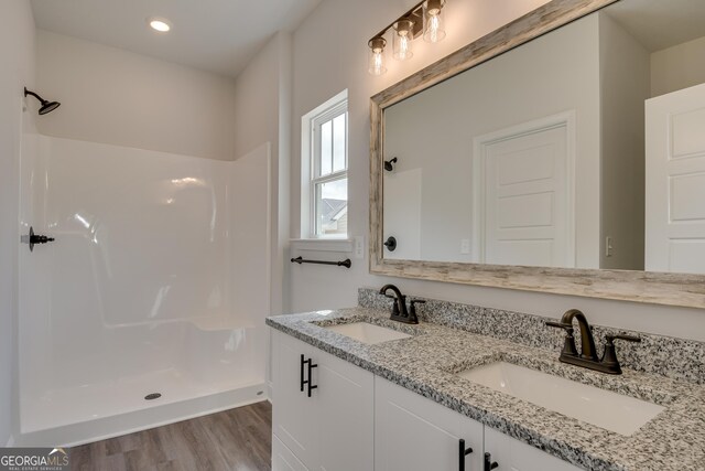 bathroom with a shower, vanity, and hardwood / wood-style flooring