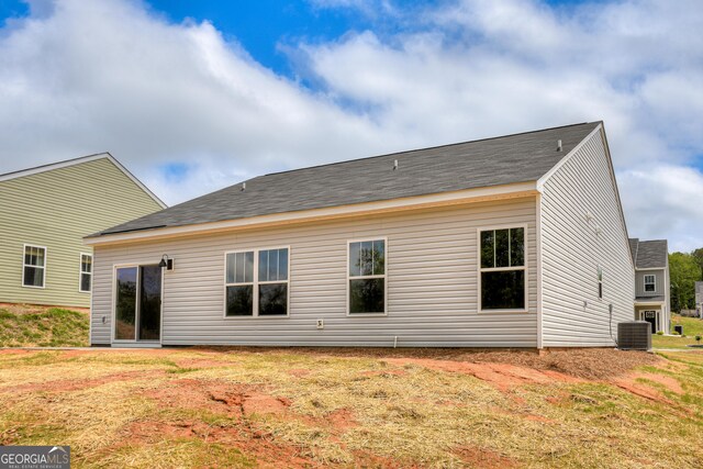 back of house featuring a lawn and central AC