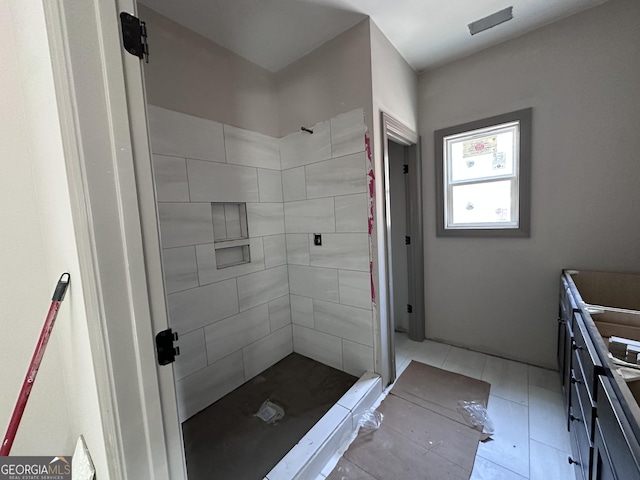 full bath with a tile shower and tile patterned floors