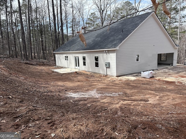 rear view of property featuring roof with shingles