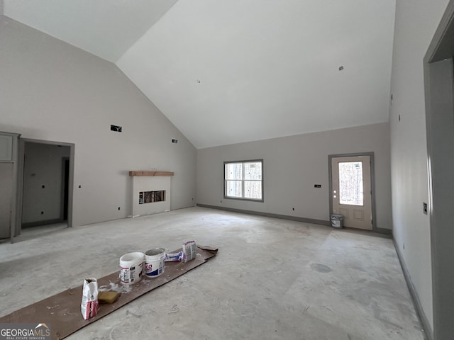 unfurnished living room with high vaulted ceiling, a fireplace, and baseboards