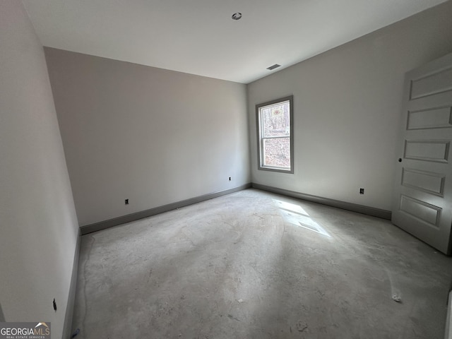 unfurnished room featuring baseboards and concrete flooring