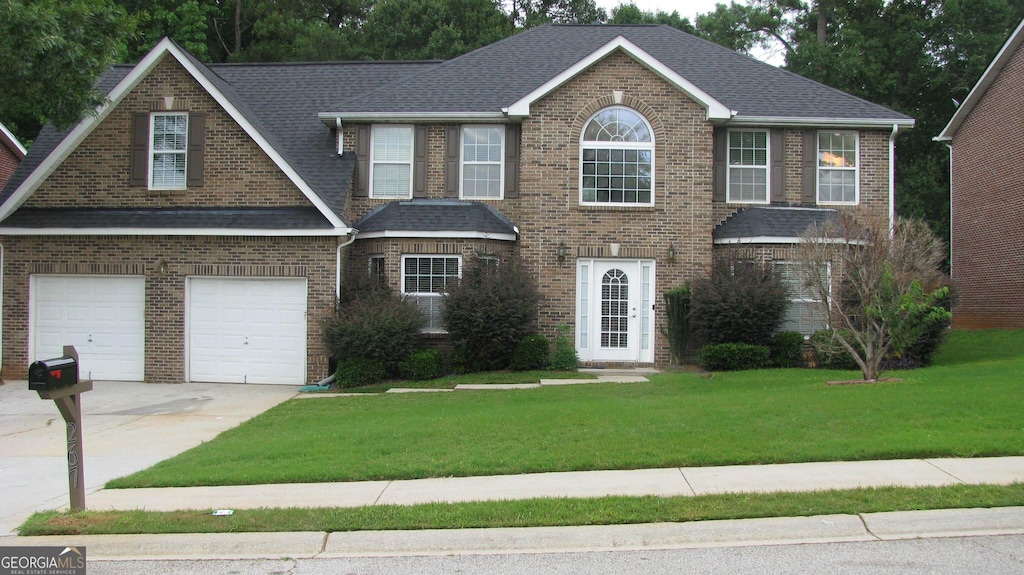 view of front of home with a garage and a front lawn