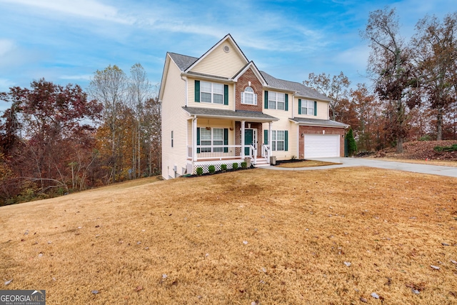 view of front facade featuring a garage, a porch, and a front yard