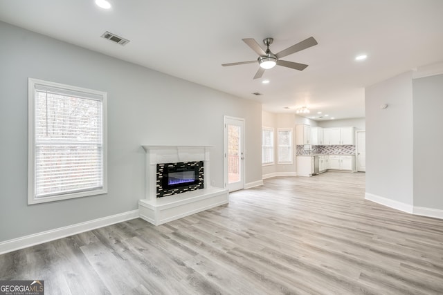 unfurnished living room with ceiling fan and light hardwood / wood-style floors