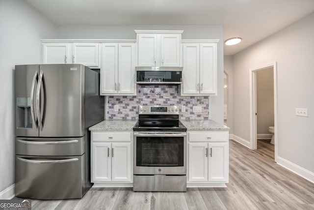 kitchen featuring white cabinetry, backsplash, light stone counters, stainless steel appliances, and light hardwood / wood-style flooring