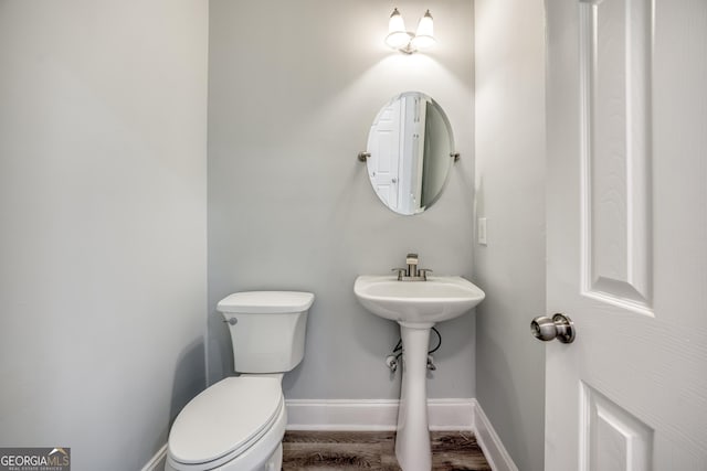 bathroom featuring hardwood / wood-style flooring and toilet