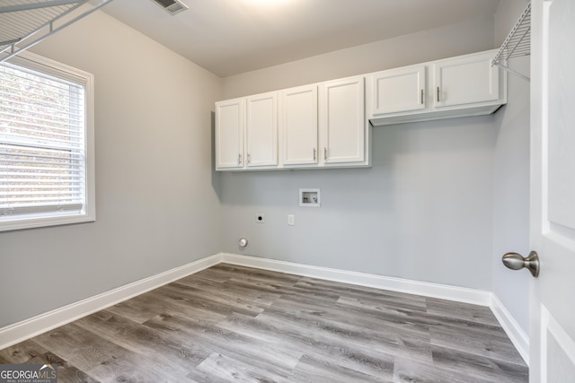 clothes washing area featuring washer hookup, light hardwood / wood-style flooring, cabinets, and hookup for an electric dryer