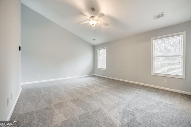 carpeted spare room with vaulted ceiling and ceiling fan