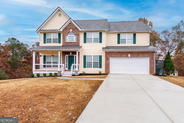 view of front of home featuring covered porch, a garage, and a front yard