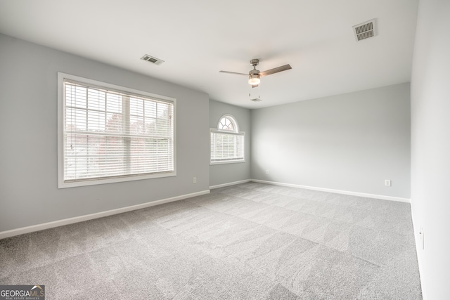 carpeted spare room with ceiling fan