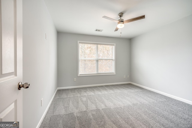 carpeted spare room with ceiling fan