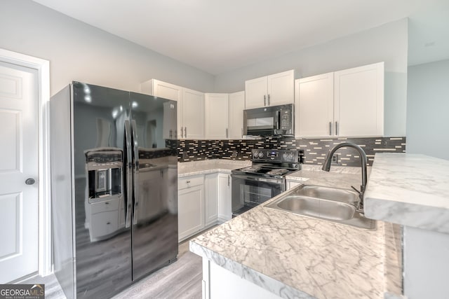 kitchen with black appliances, sink, white cabinets, backsplash, and kitchen peninsula