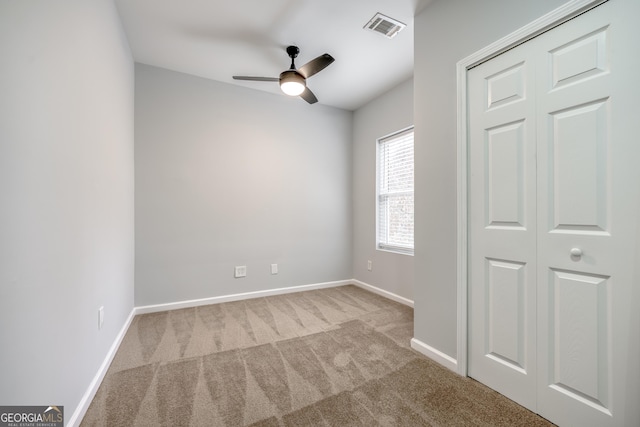 carpeted empty room featuring ceiling fan