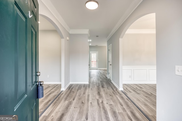 entrance foyer featuring crown molding and light hardwood / wood-style flooring