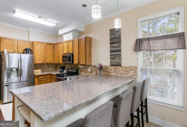 kitchen with a kitchen breakfast bar, kitchen peninsula, pendant lighting, decorative backsplash, and appliances with stainless steel finishes