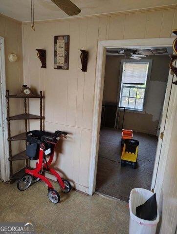 hallway featuring wooden walls