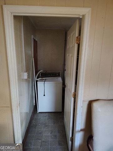 laundry room with wood walls and washer / dryer