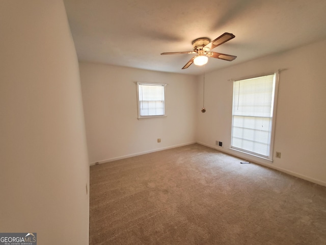 carpeted spare room with ceiling fan