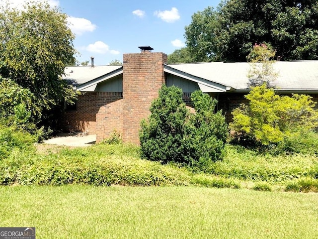 view of side of home with a lawn