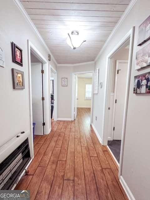 hall featuring light hardwood / wood-style flooring, crown molding, and wood ceiling