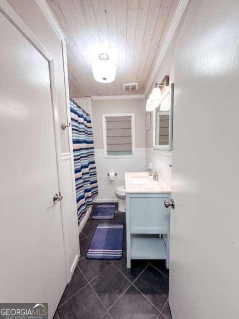 bathroom featuring vanity, crown molding, a shower with shower curtain, toilet, and wood ceiling