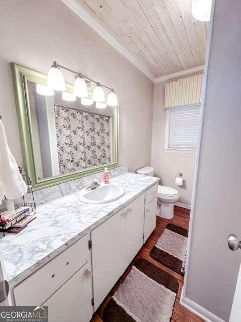 bathroom featuring vanity, wooden ceiling, crown molding, toilet, and curtained shower