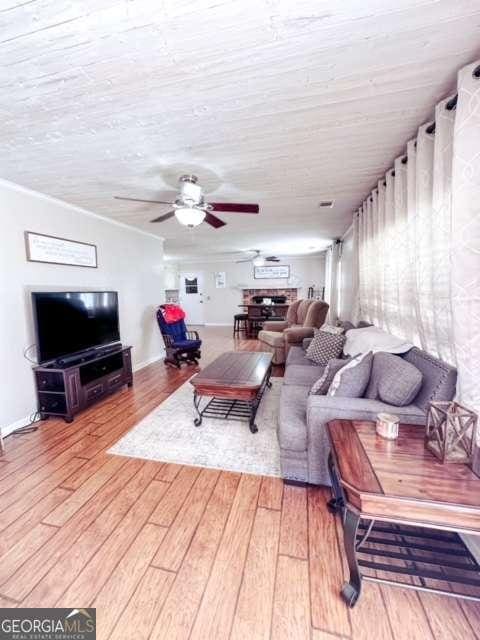 living room featuring wood-type flooring and ceiling fan