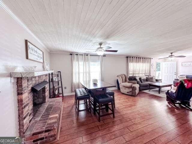 dining area with a fireplace, plenty of natural light, and hardwood / wood-style flooring