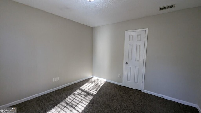 carpeted empty room with a textured ceiling