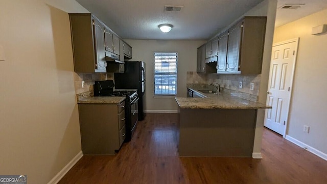 kitchen featuring kitchen peninsula, black gas stove, tasteful backsplash, and sink