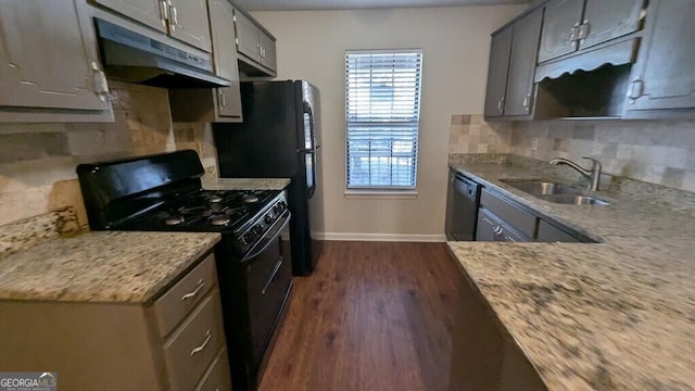 kitchen with tasteful backsplash, dark wood-type flooring, sink, black appliances, and gray cabinets