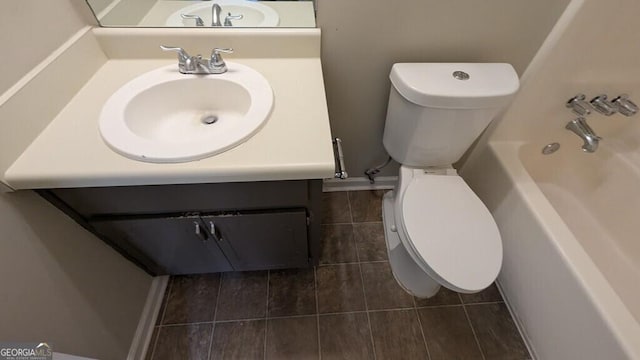 bathroom with a tub, vanity, and toilet