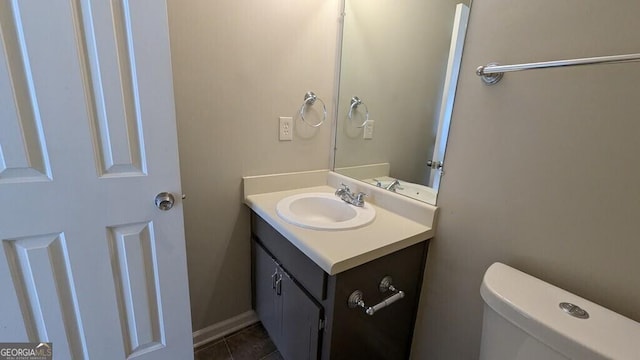 bathroom with tile patterned flooring, vanity, and toilet