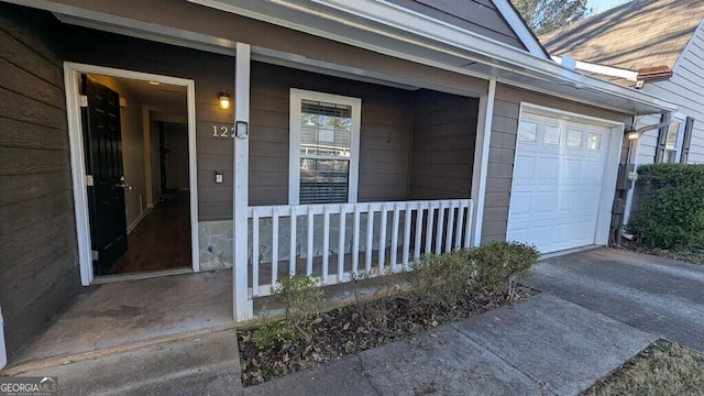 view of exterior entry with a porch and a garage