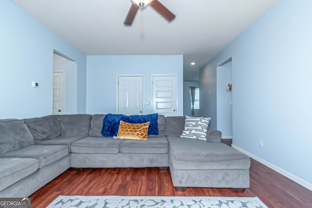 living room with ceiling fan and dark hardwood / wood-style flooring