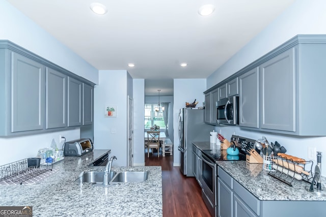 kitchen with gray cabinetry, light stone countertops, sink, and appliances with stainless steel finishes