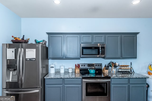 kitchen featuring stainless steel appliances and dark stone counters