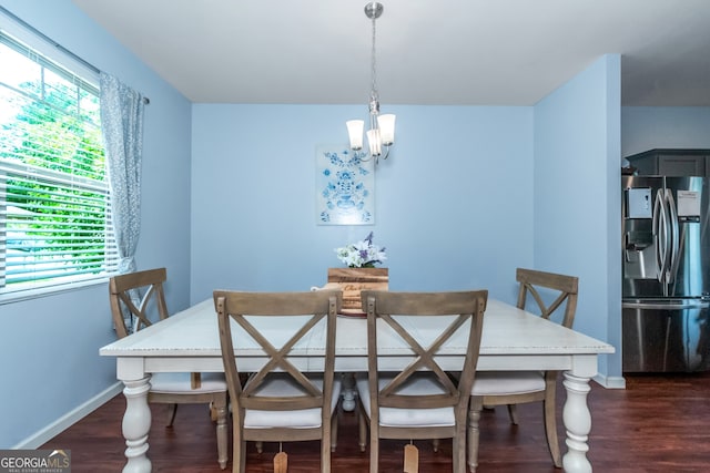 dining area featuring dark hardwood / wood-style flooring and an inviting chandelier