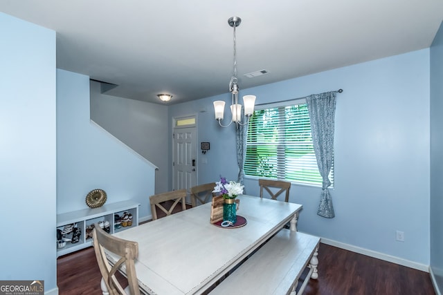 dining room with dark hardwood / wood-style flooring and a chandelier