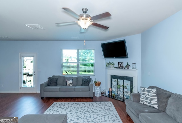 living room with ceiling fan, a premium fireplace, and dark hardwood / wood-style floors