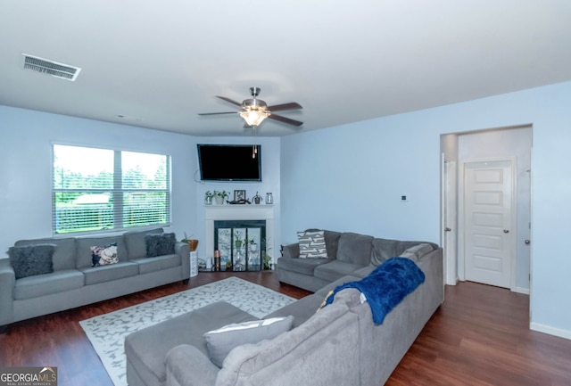 living room with dark hardwood / wood-style flooring and ceiling fan