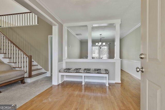 foyer featuring light hardwood / wood-style floors, ornamental molding, and a chandelier