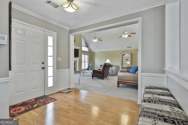 foyer entrance with light hardwood / wood-style floors and crown molding